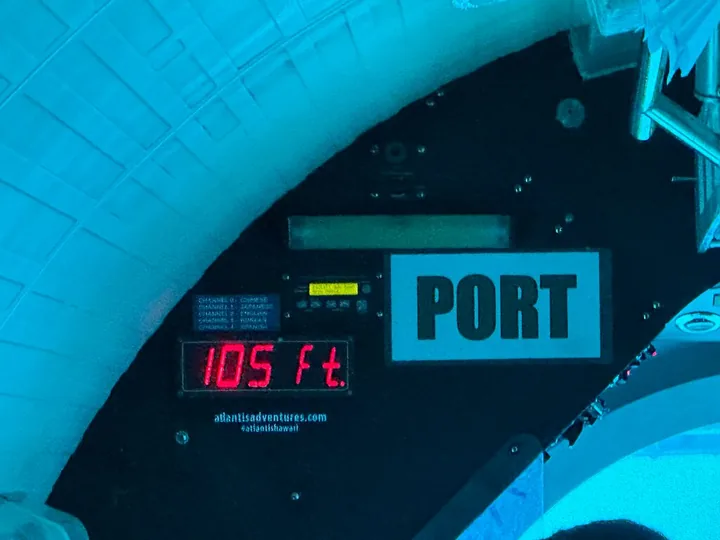 Ein Tiefenmesser im U-Boot mit 105 Fuß neben einem Bullauge
