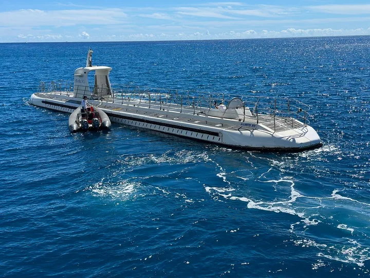The submarine and a small boat at the surface during the transfer